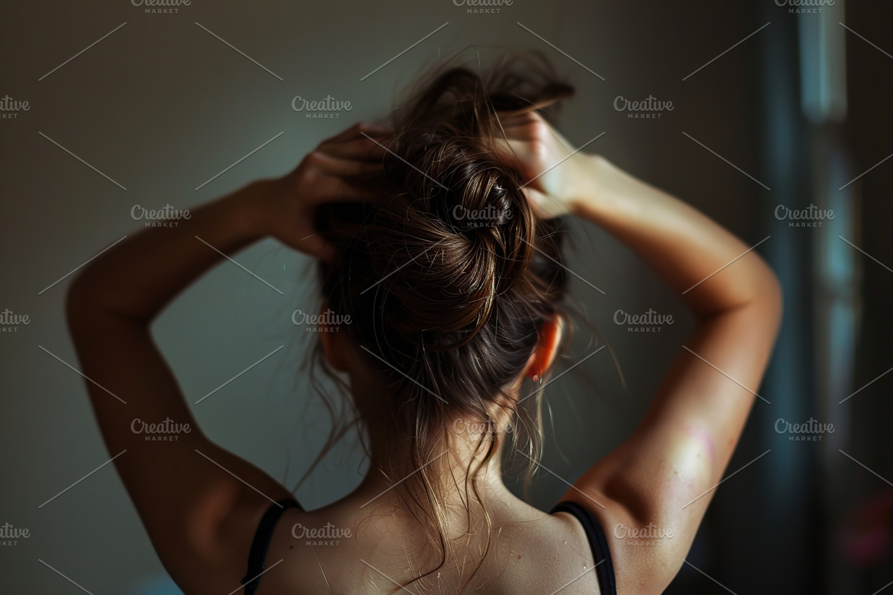 Woman tying her hair using band. Back view, a Person Photo by AlyaAnd