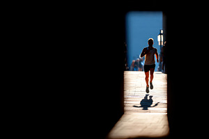 Silhouetted runner moving into bright light, a Sports & Recreation Photo by AlyaAnd