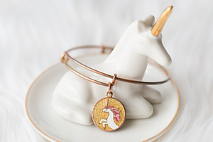 Unicorn jewelry dish + bracelet containing unicorn, white, and gold, a Beauty & Fashion Photo by Morgan Anderson