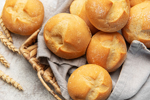 Freshly baked bread rolls in a woven basket, a Food & Drink Photo by Olena Rudo
