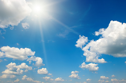 Bright sun on beautiful blue sky with white clouds.