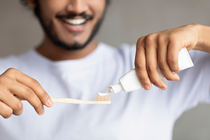 Morning time, personal oral hygiene and dental care. Young bearded man squeezin, a Person Photo by Prostock-Studio