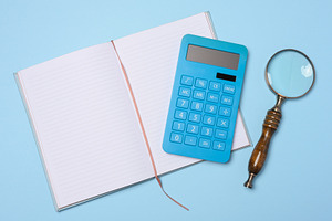 An open notebook, a blue calculator, and a vintage magnifying gl, a Business Photo by ndanko