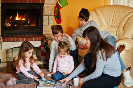 Happy young large family by a fireplace in warm living room on w, a Holiday Photo by AS photostudio