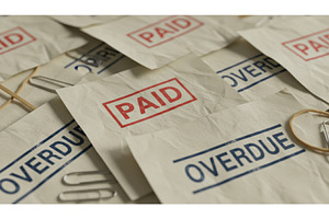 Papers scattered with red PAID stamp, a Business Photo by Igor Tichonow