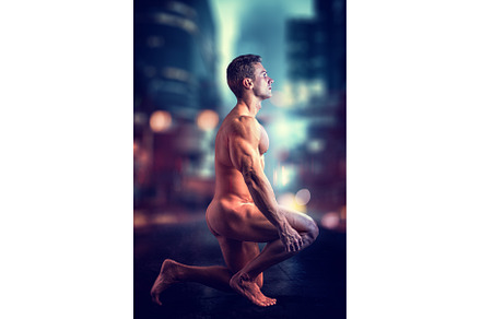 Naked man sitting in city