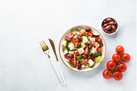 Greek salad in craft plate on white