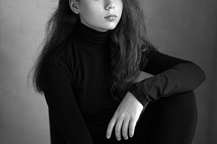 black and white photo portrait of a serious girl in black clothes in the studio, a Person Photo by SaulichPhoto
