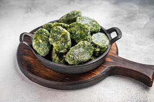 Overhead shot of frozen spinach blocks in a cast iron skillet on, a Food & Drink Photo by composter-box@mail.ru