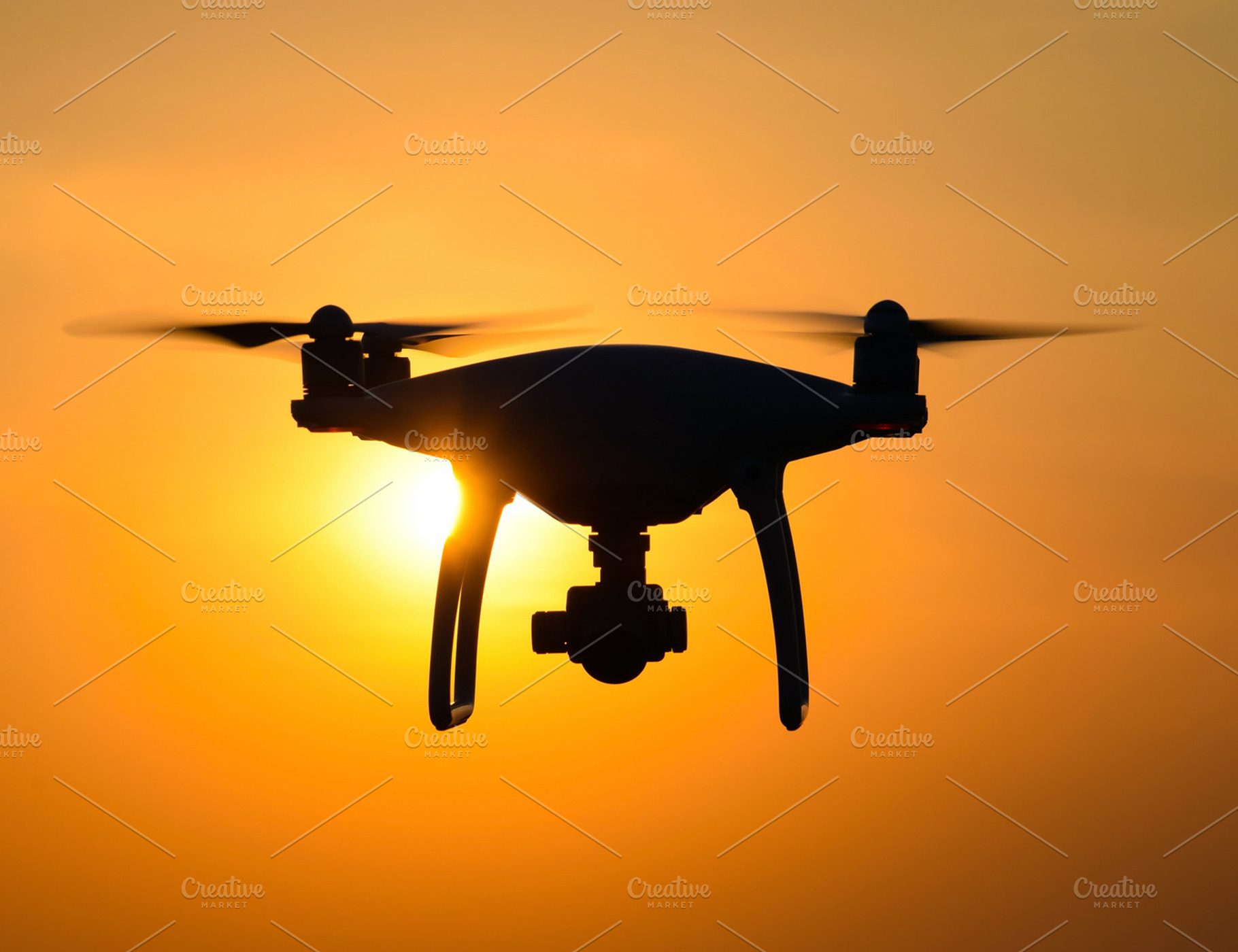 Quadrocopters silhouette against the background of the sunset featuring, a Technology Photo by ELEONIMAGES