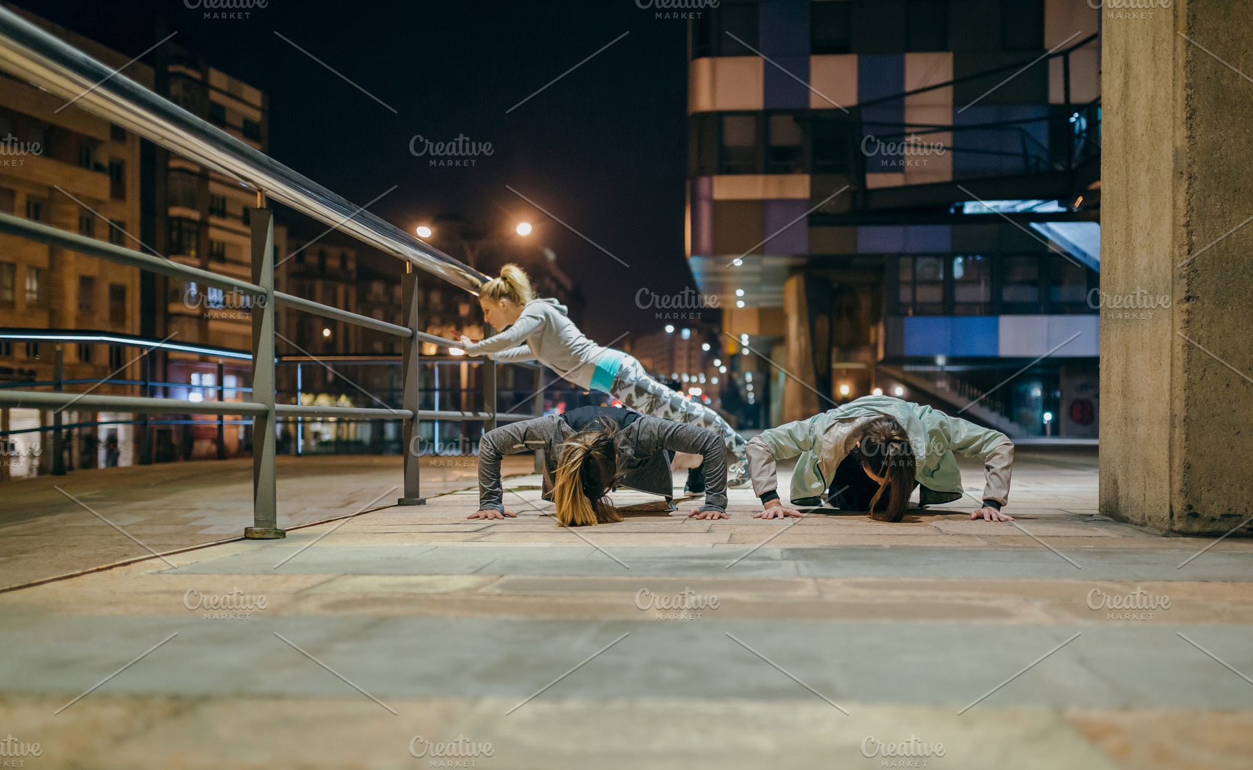 Female sport team doing push ups during training on the city at, a Sports & Recreation Photo by davidpereiras