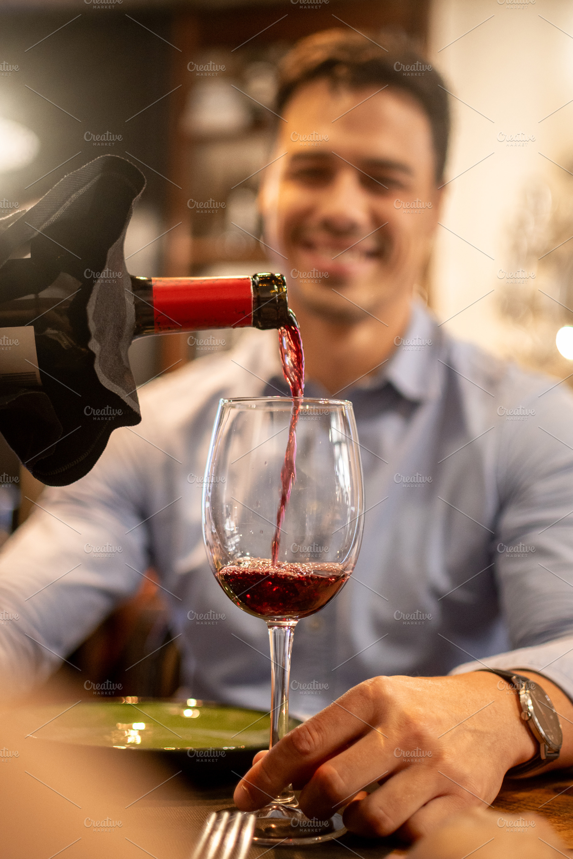 Pouring red wine into glass during romantic restaurant dinner, a Person Photo by etorres69