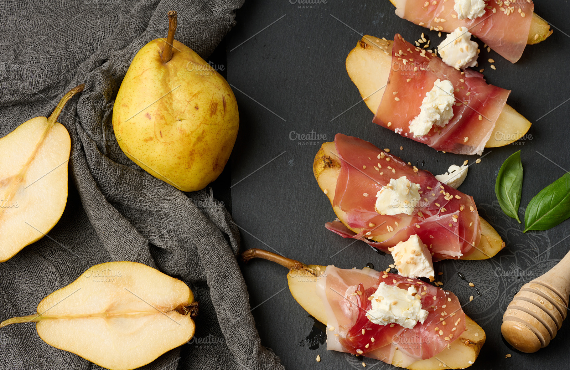 A slice of pear wrapped in prosciutto, topped with cheese and se, a Food & Drink Photo by ndanko