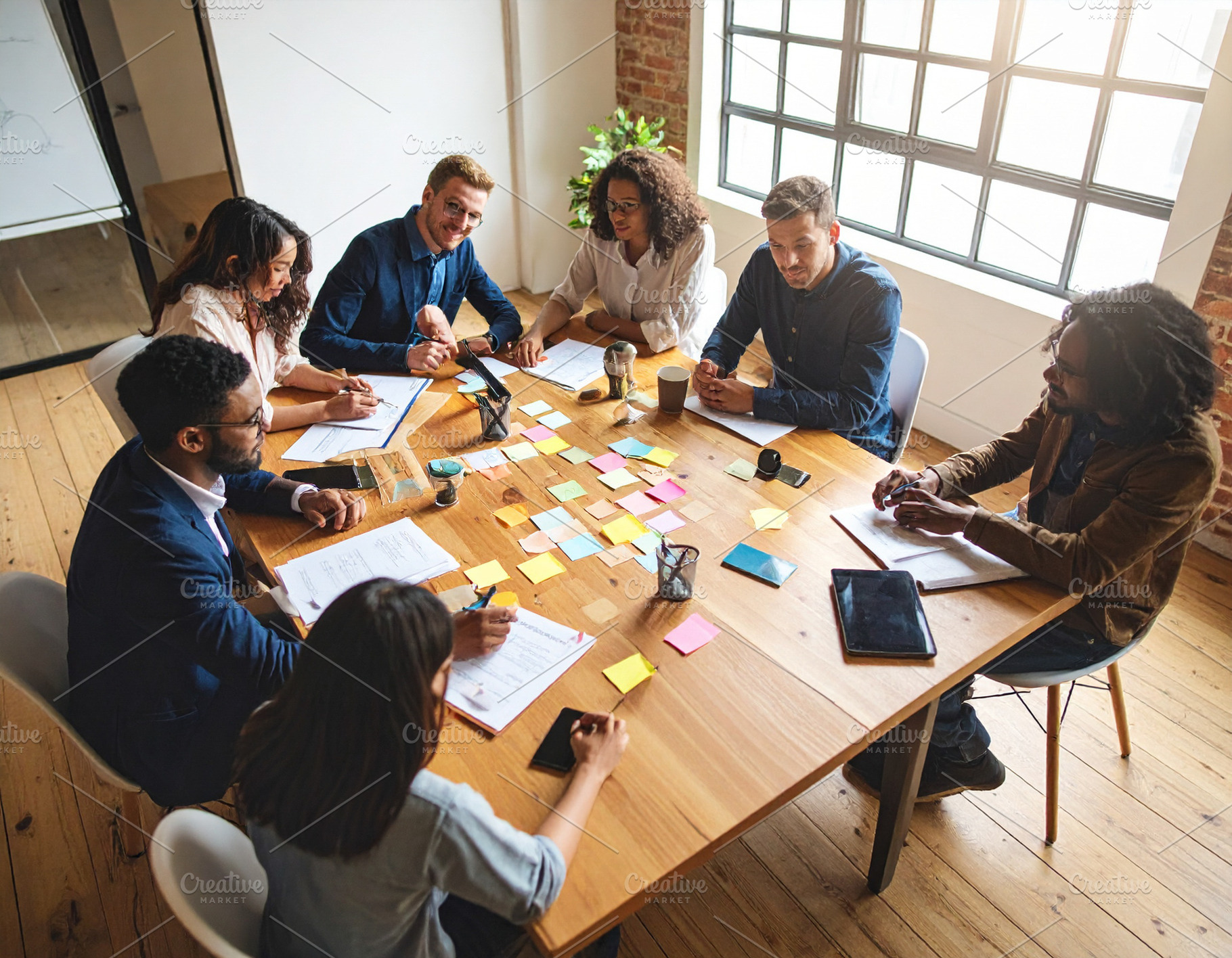 Young professionals engaged in a brainstorming session around a, a Business Photo by DanFLCreativo