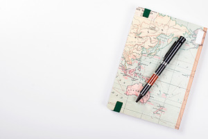 Vista superior de una libreta de viaje y un bolígrafo sobre fondo blanco