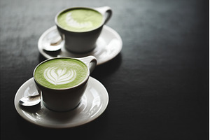 Two cups of matcha latte on black, a Food & Drink Photo by Anna Efetova