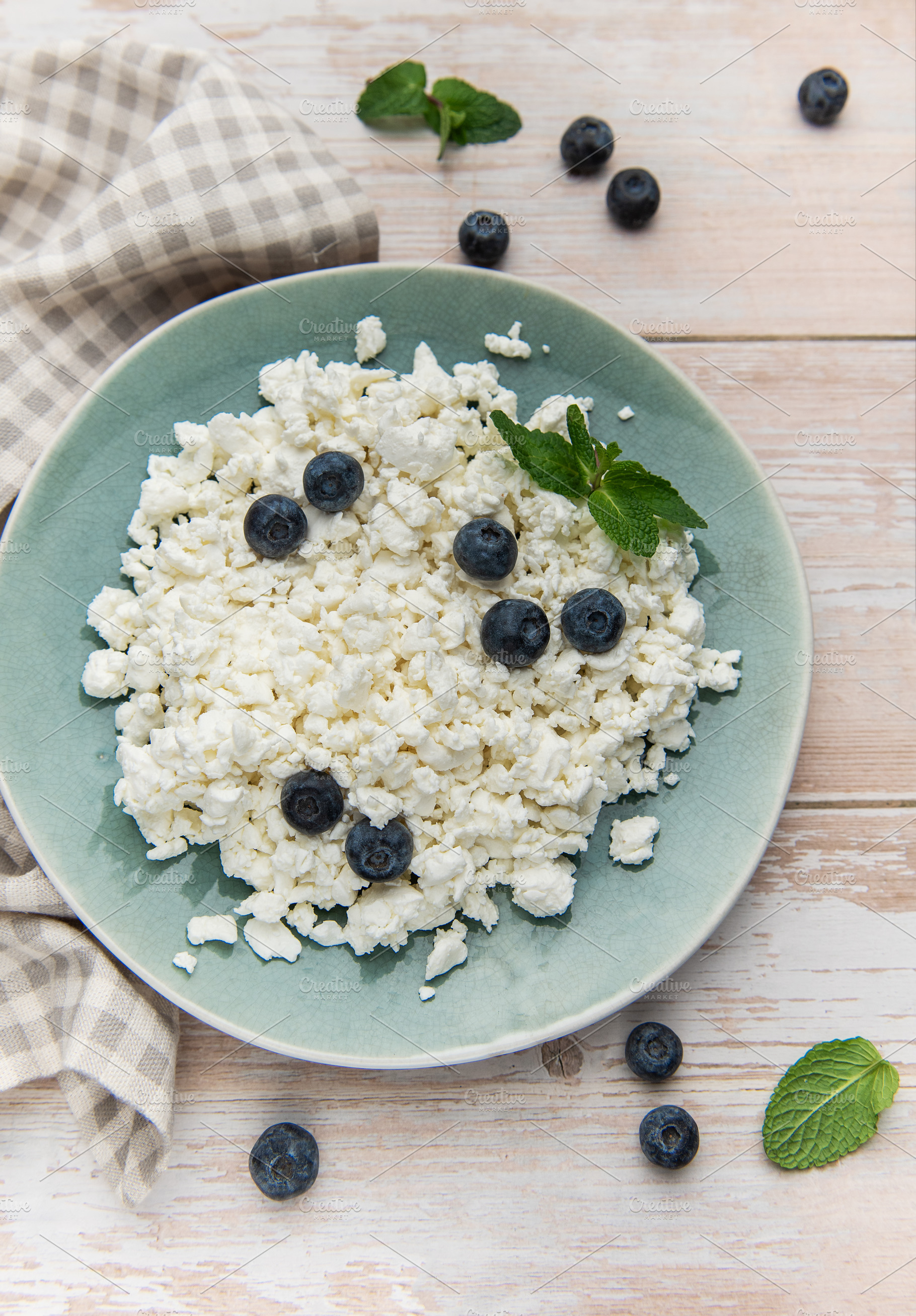 Cottage cheese with blueberries and mint on rustic table, a Food & Drink Photo by Olena Rudo