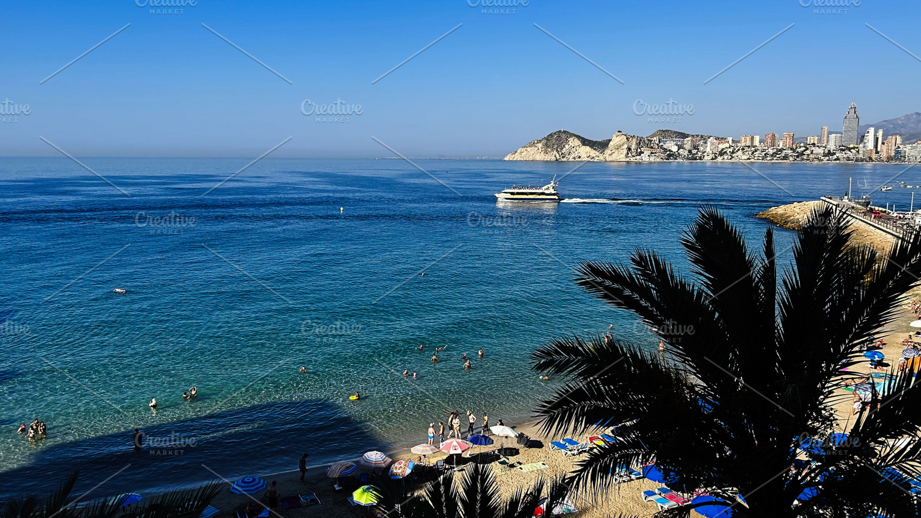 Scenic sea view of Benidorm Spain with beachgoers and skyscrapers along the coa, a Photo by AS photostudio