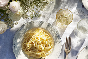 Fresh pasta dish serving outdoors under summer sunlight with ele, a Photo by Studio ANNA