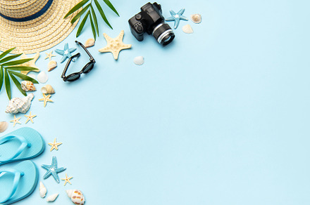 Summer accessories creating frame on light blue background with