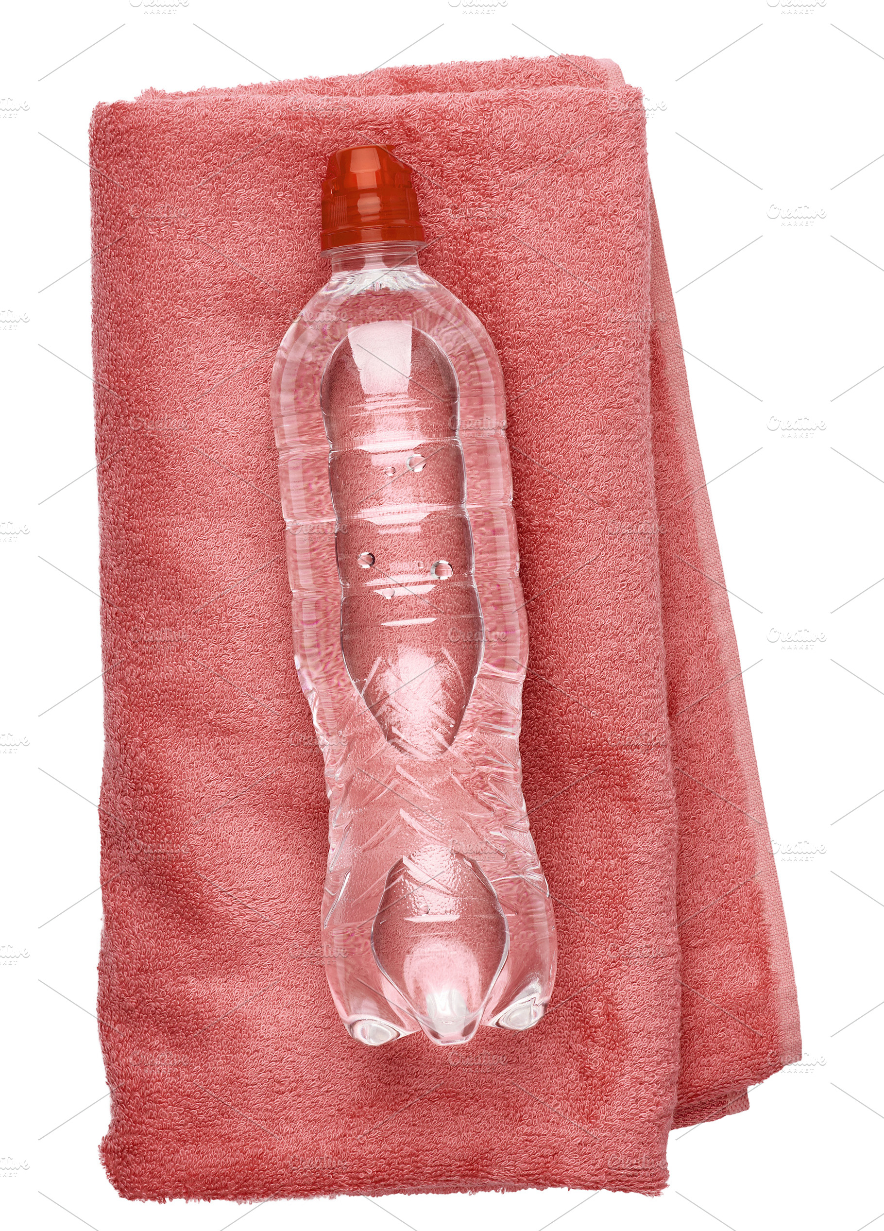 A clear plastic water bottle lies vertically on a folded pink te, a Food & Drink Photo by ndanko