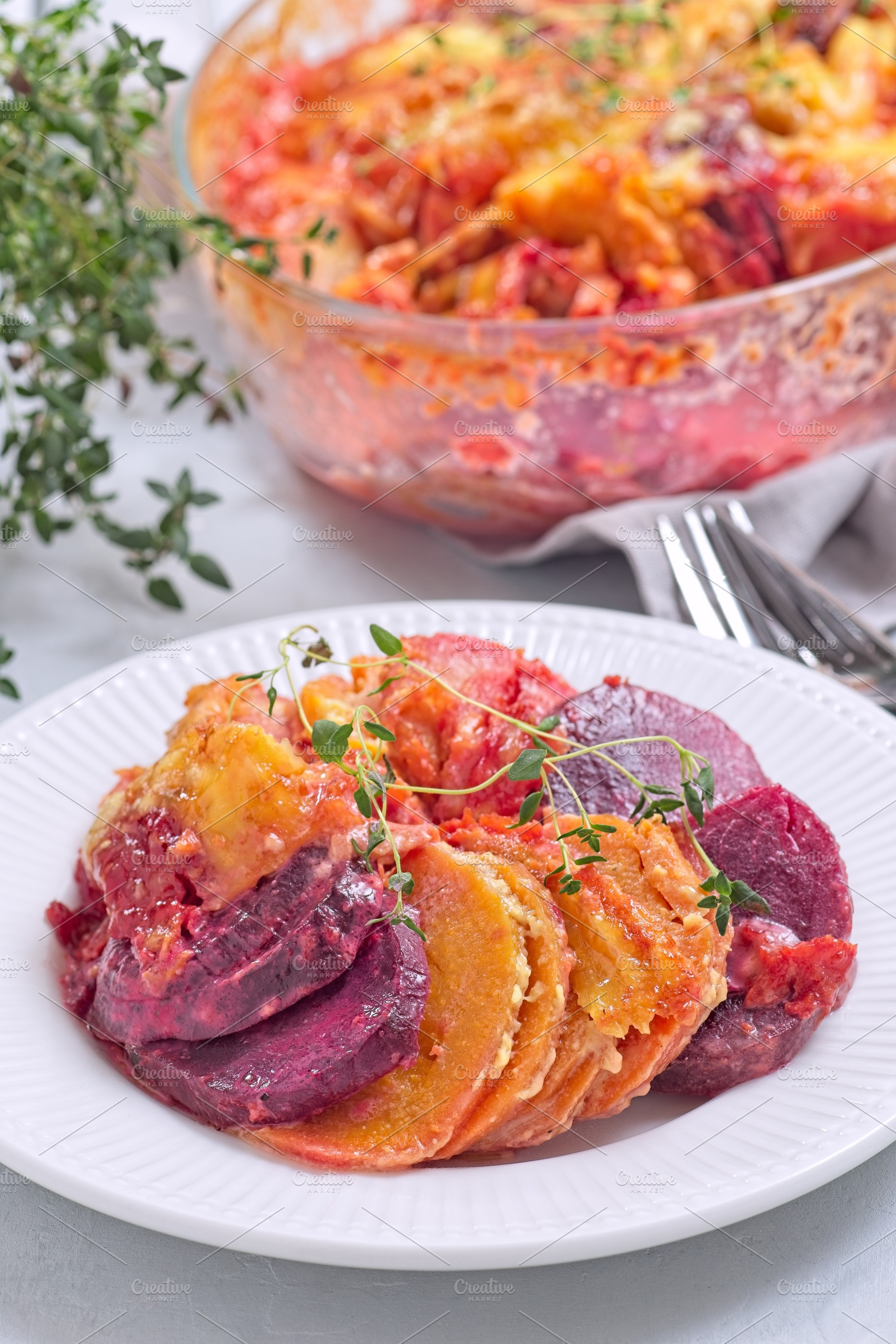 Sweet potato, parsnips and beet root au gratin with thyme and melted cheese, on, a Food & Drink Photo by iuliia_n
