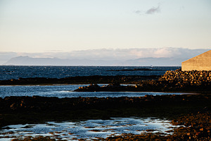 Serene coastal landscape view of Iceland with distant mountains and tranquil wa, a Nature Photo by AS photostudio