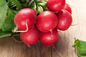 Fresh whole radishes with green tops on wooden surface, a Food & Drink Photo by Olena Rudo