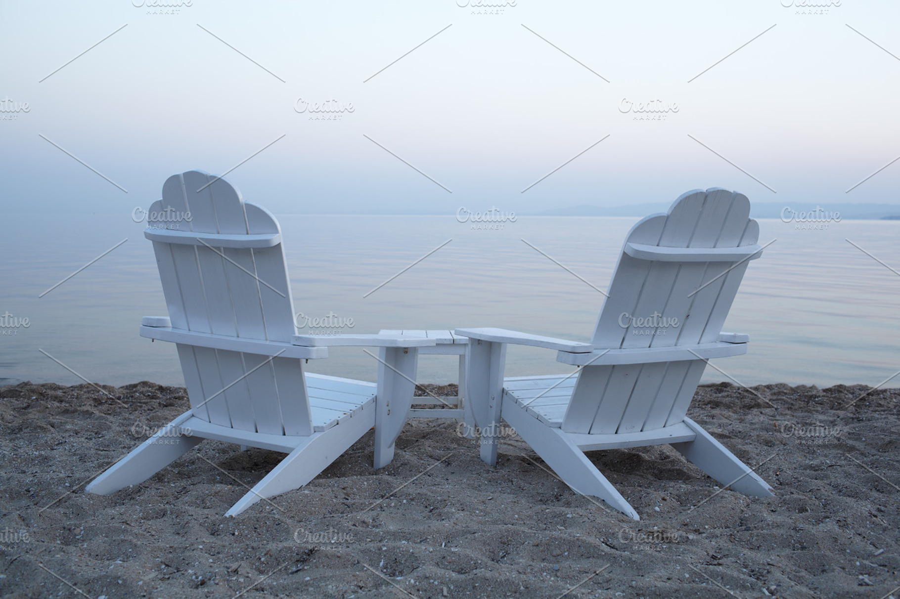 Empty wooden deck chairs on a beach featuring chair, two, and nobody, a Person Photo by Grey Coast Media