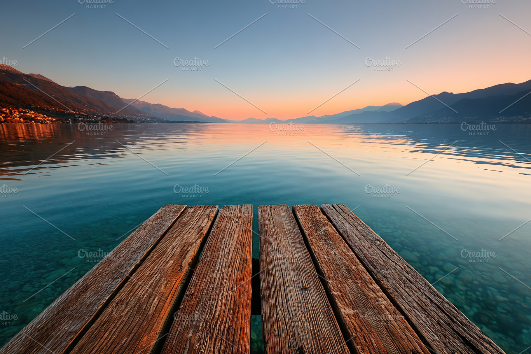 Twilight reflections on a tranquil lakeside dock with serene mountain views, a Photo by AlyaAnd