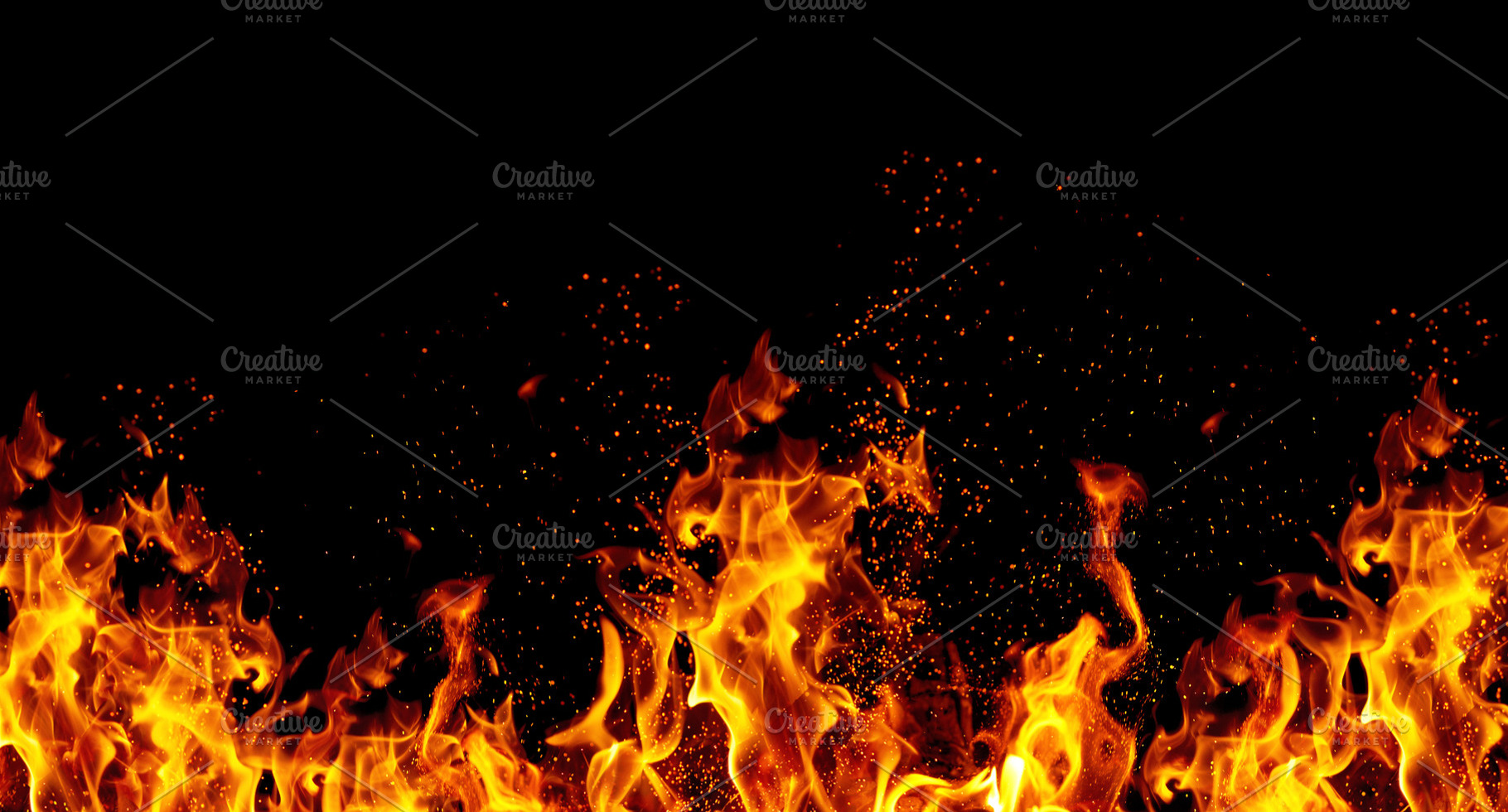 Bright orange flames and sparks on black background, an Abstract Photo by ndanko