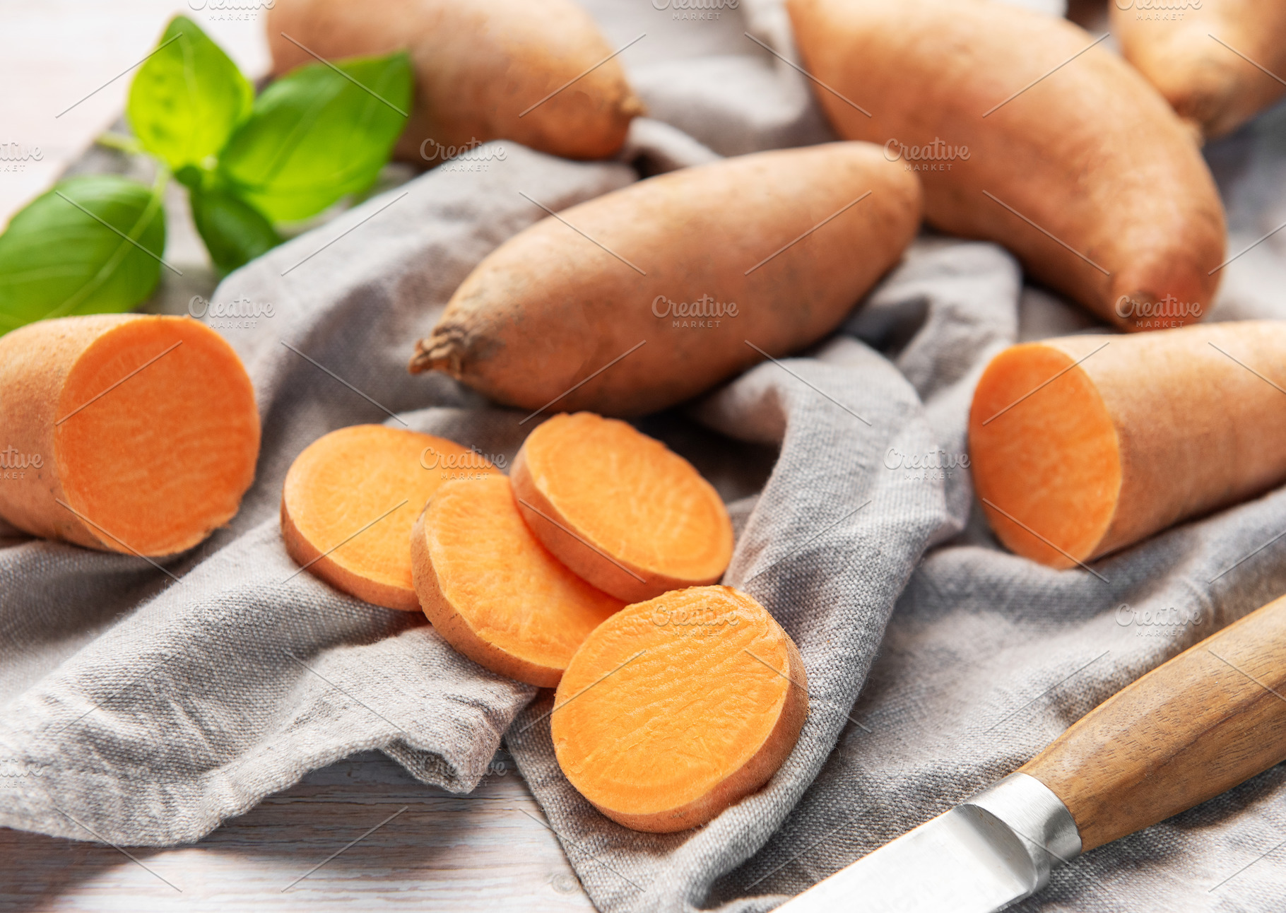 Sweet potato slices with whole root vegetables and basil, a Food & Drink Photo by Olena Rudo