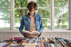 Middle aged woman reading a book, a Person Photo by BOOCYS