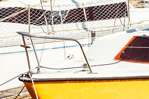 Yellow sailboat in sunny marina, a Photo by Dvoevnore photos