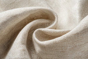 Beige linen fabric in soft folds showing detailed woven texture, an Abstract Photo by José Manuel Gelpi