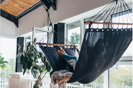 Woman is lying at home in a hammock, a Person Photo by undrey