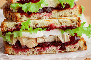 Turkey or chicken sandwich featuring berries, berry, and board