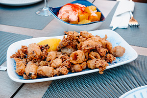 spanish chipirones and patatas bravas on a table, a Photo by Nito