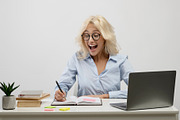 Surprised businesswoman working on laptop and taking notes in notebook, surpris, a Photo by Prostock-Studio (Thumbnail 2 of 2)