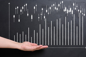 A hand reaches out towards a stock market chart drawn in white o, a Business Photo by ndanko