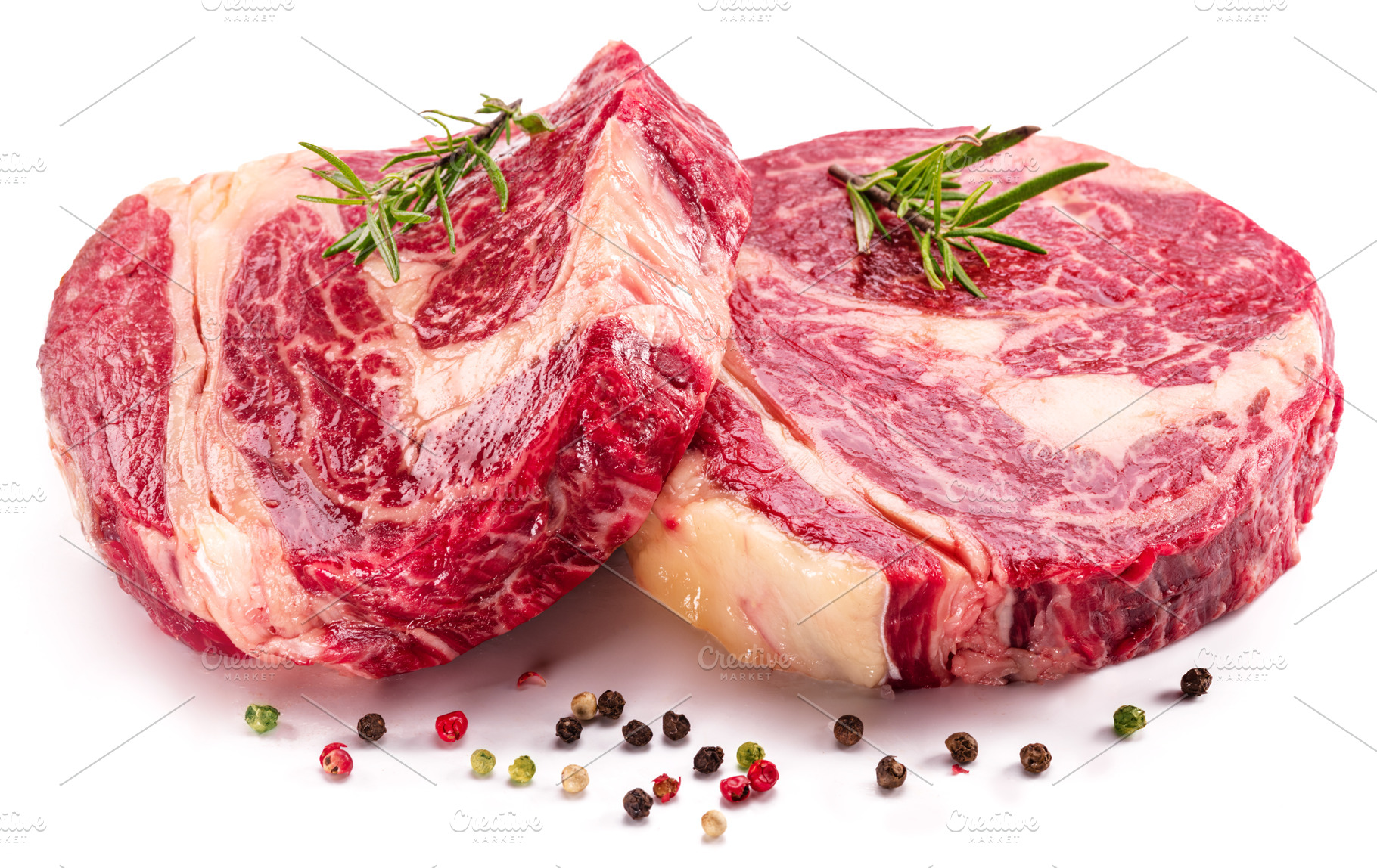 Raw beef steaks with herbs and spices ready for cooking on white, a Food & Drink Photo by Volff