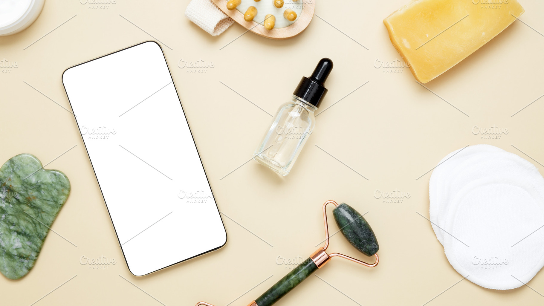 Smartphone mockup surrounded by skincare items: marble face roller, gua sha too, a Photo by matucha