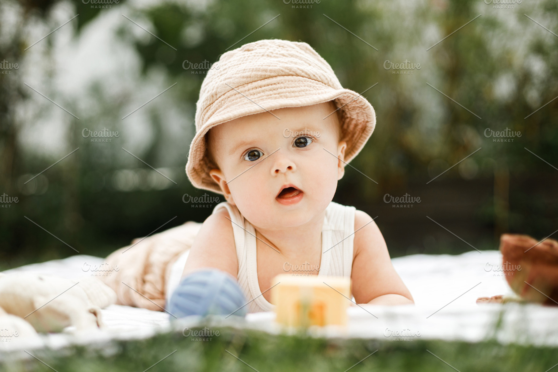 Beautiful happy baby lying on blanket with toys on background of, a Person Photo by Sonjachni