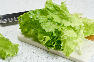 Fresh, crisp lettuce leaves are arranged on a white and wooden c, a Food & Drink Photo by ndanko