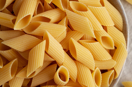 Raw Organic Dry Pennoni Pasta in a Bowl, top view. Close-up., a Food & Drink Photo by LiudmylaChuhunova
