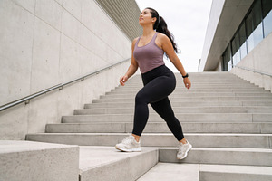 Woman exercising on concrete stairs, a Photo by Dvoevnore photos