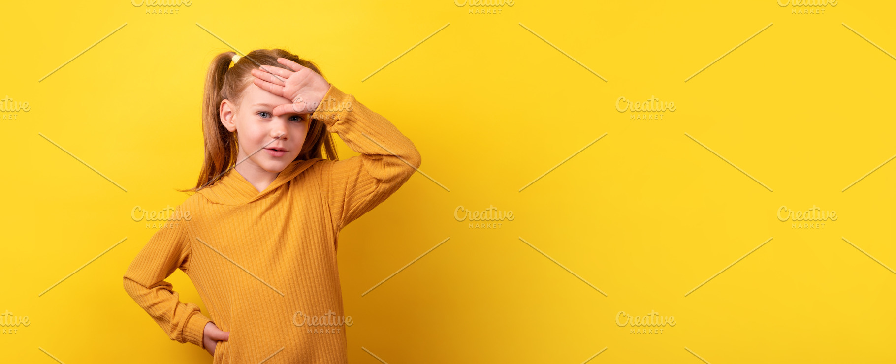 Young girl in a mustard sweater holding her hand to her forehead, a Person Photo by Ales Munt