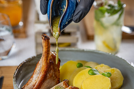 Chef pouring sauce on grilled pork ribs