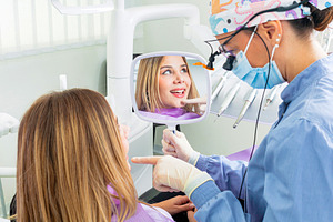 Dentist showing teeth to patient with mirror in dental clinic, a Health & Medical Photo by Antonio Gravante Market