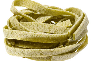 Nest of dry green egg pasta tagliatelle with spinach, isolated b, a Food & Drink Photo by ndanko